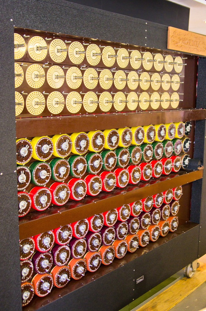 A rebuilt Turing–Welchman Bombe: a tall cabinet covered in rows of coloured rotating drums.